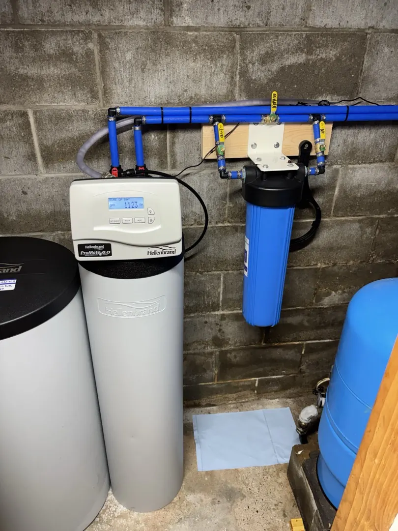 Hellenbrand water softener and big blue sediment filter installed on a block basement wall